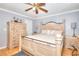 Bedroom showcasing a large bed, hardwood floors, ceiling fan, and a light-colored dresser at 2573 Mistletoe Ln, Snellville, GA 30039