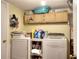 Laundry room featuring a washer, dryer, storage cabinets, and various cleaning supplies at 2573 Mistletoe Ln, Snellville, GA 30039
