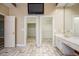 Bathroom leading into dual walk-in closets and featuring stone-like tile and double doors at 6065 Standard View Dr, Duluth, GA 30097