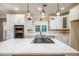 Bright kitchen island, stainless steel appliances, white cabinets, and pendant lighting at 6065 Standard View Dr, Duluth, GA 30097