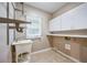 Neutral laundry room with storage cabinets, sink, and clothes rack for functional convenience at 6065 Standard View Dr, Duluth, GA 30097