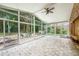 Enclosed sunroom with brick floor, stone accent wall, and floor to ceiling windows with backyard view at 6065 Standard View Dr, Duluth, GA 30097