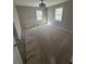 A carpeted bedroom features neutral walls, bright windows, and an elegant chandelier at 1457 Richland Road Southwest, Atlanta, GA 30310