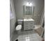 Bright bathroom with white vanity, square mirror, and standard toilet at 1457 Richland Sw Rd, Atlanta, GA 30310
