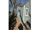 Side view of a home featuring gray siding, white trim, and a shadow cast over a leaf-strewn yard at 1457 Richland Sw Rd, Atlanta, GA 30310