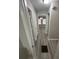 Hallway with modern gray wood-look floors leading to a room with a chandelier at 1457 Richland Sw Rd, Atlanta, GA 30310