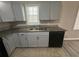 The well-lit kitchen features gray cabinets, stainless steel sink, and granite countertops at 1457 Richland Sw Rd, Atlanta, GA 30310