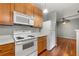 Bright kitchen with wood floors, white appliances, and light-colored cabinetry at 1995 Liberty Hts, Fairburn, GA 30213