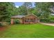 Charming brick home featuring a covered front porch, mature trees, and a well-manicured lawn at 3510 Dunn Se St, Smyrna, GA 30080