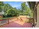 A wooden back deck with stairs and a red railing offers a great view of the backyard at 961 Lindbergh Ne Dr, Atlanta, GA 30324