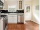 Stainless steel appliances, white cabinets, black tile backsplash and hardwood flooring at 961 Lindbergh Ne Dr, Atlanta, GA 30324