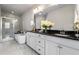 Elegant bathroom with dual vanities, a glass-enclosed shower, and a standalone tub at 209 Snapdragon St, Woodstock, GA 30188