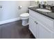 Modern bathroom vanity with dark granite countertop and white cabinets in a well-lit space at 209 Snapdragon St, Woodstock, GA 30188