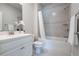 Bright bathroom with a shower-tub combo, a white vanity, and neutral tile, offering a clean and functional design at 209 Snapdragon St, Woodstock, GA 30188