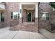 Welcoming brick porch with black iron railings leads to the front door of this charming townhome at 209 Snapdragon St, Woodstock, GA 30188