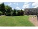 Spacious lawn area in a well-kept community, featuring trees, grassy fields, and fenced perimeters at 209 Snapdragon St, Woodstock, GA 30188
