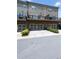 View of townhome garages and driveway, complemented by neat landscaping and neutral exteriors at 209 Snapdragon St, Woodstock, GA 30188