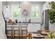 Modern kitchen with white cabinets, stainless steel appliances, island with seating, and natural light at 209 Snapdragon St, Woodstock, GA 30188