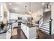 Well-designed kitchen with central island, stainless steel appliances, and adjacent staircase at 209 Snapdragon St, Woodstock, GA 30188