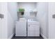 Efficient laundry room with washer, dryer, and storage shelves for laundry essentials at 209 Snapdragon St, Woodstock, GA 30188