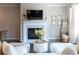 Inviting living room with white sofas, fireplace, and natural light streaming through the windows at 209 Snapdragon St, Woodstock, GA 30188