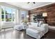 Inviting living room with wood accent wall, plush seating, and abundant natural light, perfect for relaxation and entertainment at 209 Snapdragon St, Woodstock, GA 30188