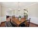 Inviting dining room with modern chandelier, wainscoting and archway leading to the living room at 250 Kensington Trce, Stockbridge, GA 30281
