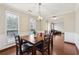 Elegant dining area with hardwood floors, wainscoting, and modern lighting with living room access at 250 Kensington Trce, Stockbridge, GA 30281