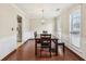 Bright dining room featuring hardwood floors, wainscoting, stainless steel refrigerator, and modern lighting at 250 Kensington Trce, Stockbridge, GA 30281