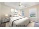 This bright, staged main bedroom has windows that offer natural light and neutral decor at 250 Kensington Trce, Stockbridge, GA 30281