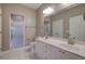 Bathroom with double sink vanity, large mirror, shower, and tile flooring at 2500 Rosehill Cir, Lithia Springs, GA 30122