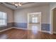 Dining room with chair rail trim and wood floors, flowing into the kitchen at 2500 Rosehill Cir, Lithia Springs, GA 30122