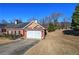 Charming brick home featuring a two-car garage, complemented by a well-maintained lawn and driveway at 2500 Rosehill Cir, Lithia Springs, GA 30122