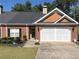 Charming brick home featuring a two-car garage, complemented by a well-maintained lawn and driveway at 2500 Rosehill Cir, Lithia Springs, GA 30122