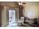 Cozy Bedroom with a black baby crib, an armchair with footstool, and a ceiling fan with lights at 2720 Stillwater Lake Ln, Marietta, GA 30066