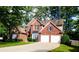 Beautiful two-story brick home with a two-car garage and a well-maintained lawn on a bright, sunny day at 2720 Stillwater Lake Ln, Marietta, GA 30066