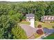 An aerial view shows a home on a tree-lined street, mature trees, and manicured lawns at 7650 Abbey Glen Dr, Cumming, GA 30028