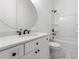 Bathroom featuring a large round mirror, white cabinets, a tiled floor, and a combined tub and shower at 7650 Abbey Glen Dr, Cumming, GA 30028