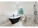 Modern bathroom with a black soaking tub, marble tiling and glass enclosed shower at 7650 Abbey Glen Dr, Cumming, GA 30028