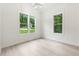 Charming bedroom with hardwood floors, featuring natural light from large windows, and a modern chandelier at 7650 Abbey Glen Dr, Cumming, GA 30028