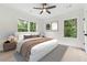 Bright bedroom features a ceiling fan, neutral colors, and views of the trees outside from multiple windows at 7650 Abbey Glen Dr, Cumming, GA 30028
