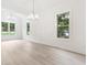 Spacious dining room boasting hardwood floors, large windows and modern light fixtures at 7650 Abbey Glen Dr, Cumming, GA 30028