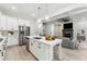 Open-concept kitchen with a large island, stainless steel appliances, and a view into the adjacent living space at 7650 Abbey Glen Dr, Cumming, GA 30028