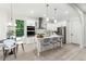 Bright kitchen with stainless steel appliances, white cabinetry, an island with seating, and modern pendant lighting at 7650 Abbey Glen Dr, Cumming, GA 30028