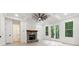 Bright open-plan living room with stone fireplace, hardwood floors, coffered ceilings, and access to bathroom at 7650 Abbey Glen Dr, Cumming, GA 30028