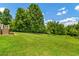 Expansive backyard with lush greenery, mature trees, and gentle slope at 195 Connesena Rd, Kingston, GA 30145
