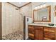 Bathroom featuring decorative river rock flooring in the walk in shower and wooden cabinetry at 195 Connesena Rd, Kingston, GA 30145