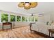 Bright bedroom with large windows, hardwood floors, ceiling fan, and views of the surrounding green trees at 195 Connesena Rd, Kingston, GA 30145