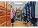 Walk-in closet featuring an array of clothing items and built in wooden storage drawers at 195 Connesena Rd, Kingston, GA 30145