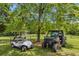 On the grounds find a golf cart and a UTV vehicle parked on the manicured lawn beneath the shade of a tree at 195 Connesena Rd, Kingston, GA 30145